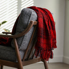 black and red plaid throw blanket styled over a couch 