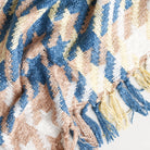 boucle's yellow beige and blue houndstooth throw blanket styled with tassels