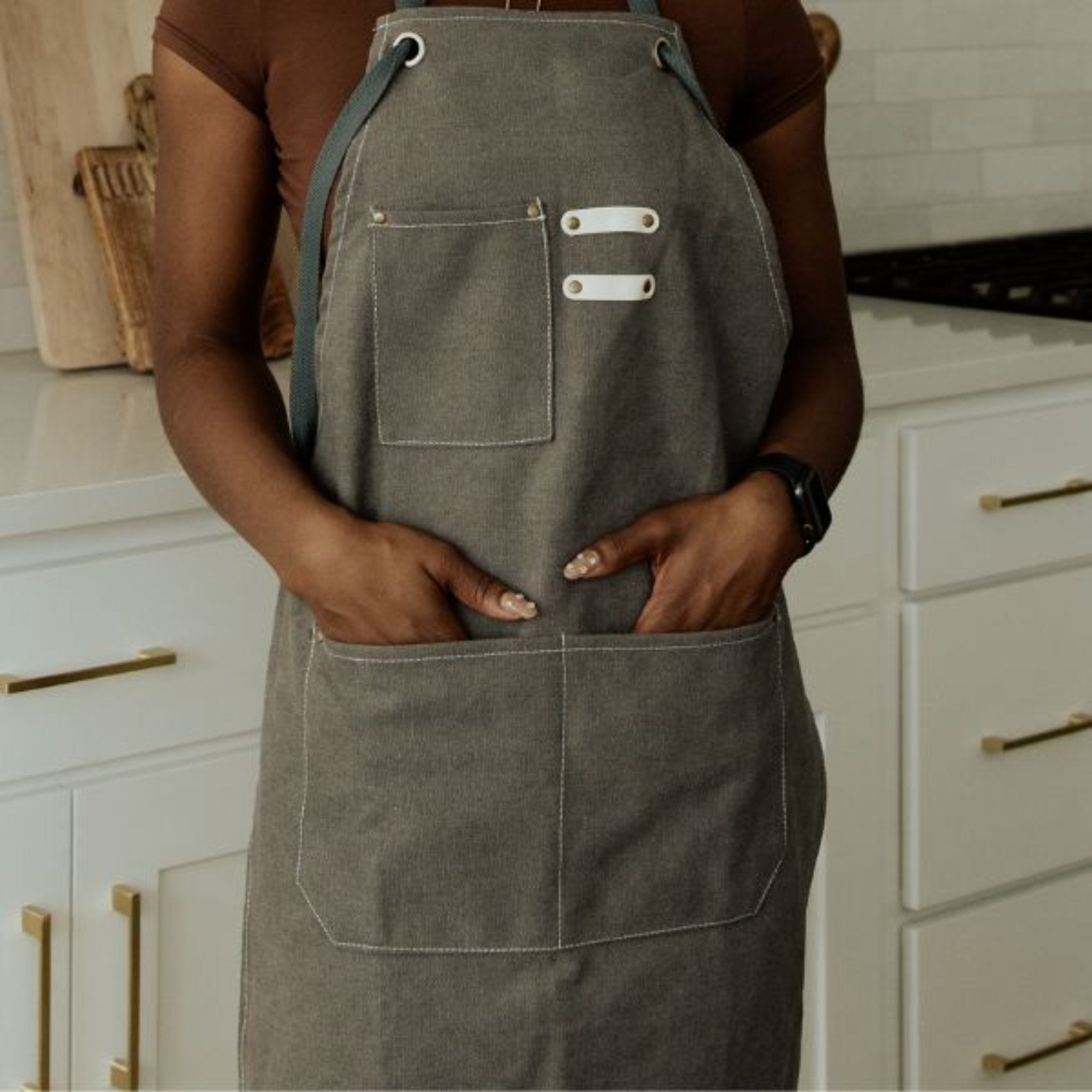 brown apron with 3 pockets on model