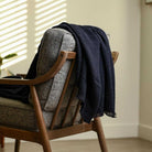 wool navy blue styled throw blanket draped over a chair home decor