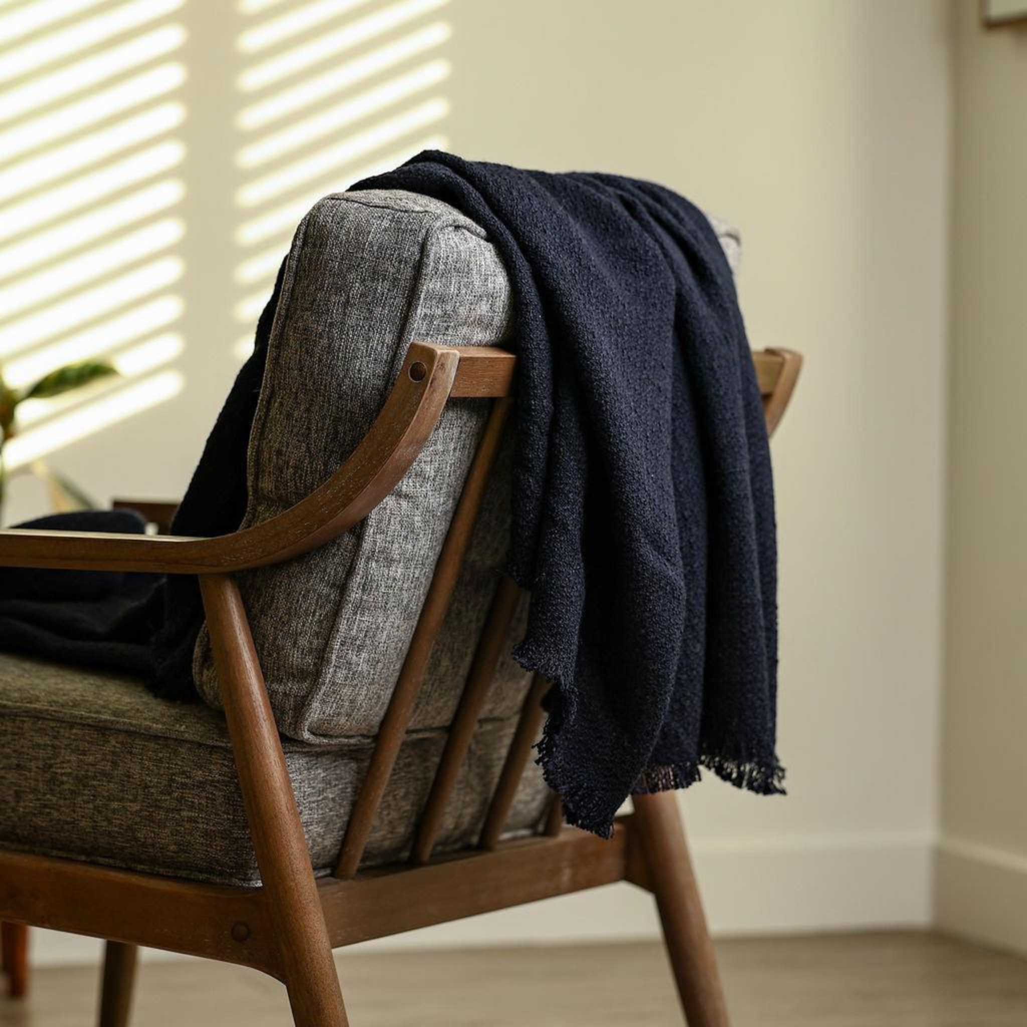 wool navy blue styled throw blanket draped over a chair home decor