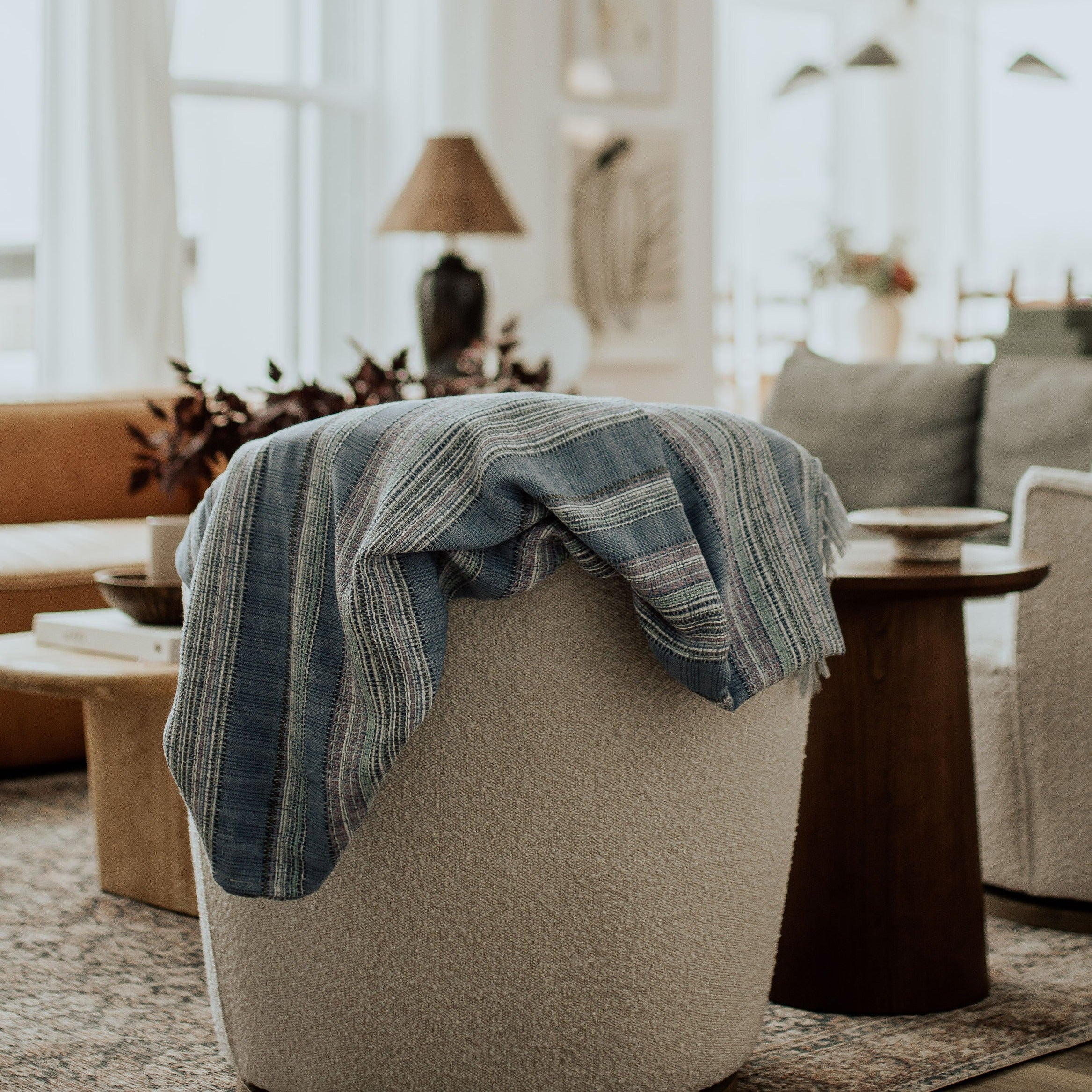 periwinkle throw blanket displayed over a white sofa with striped and blue hues and colors