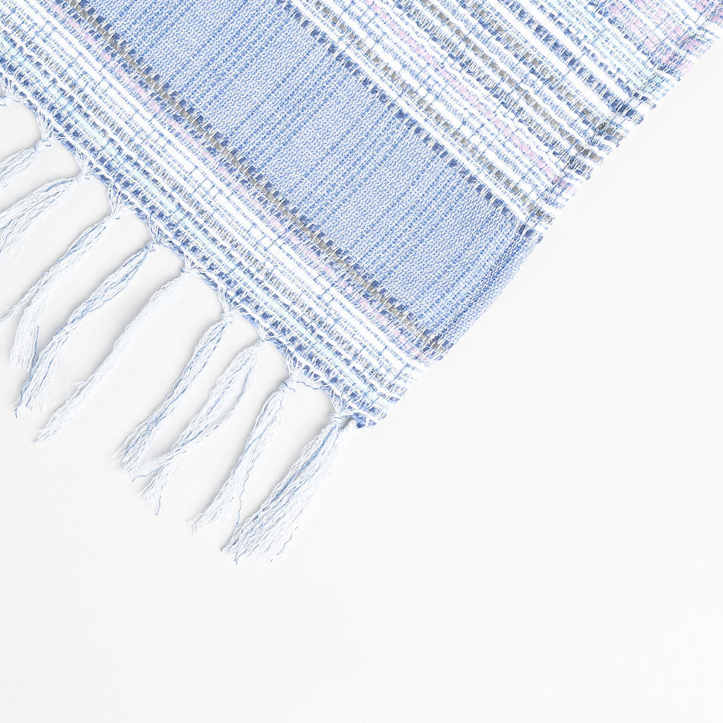 light periwinkle summer blanket displayed to show the blue tassels