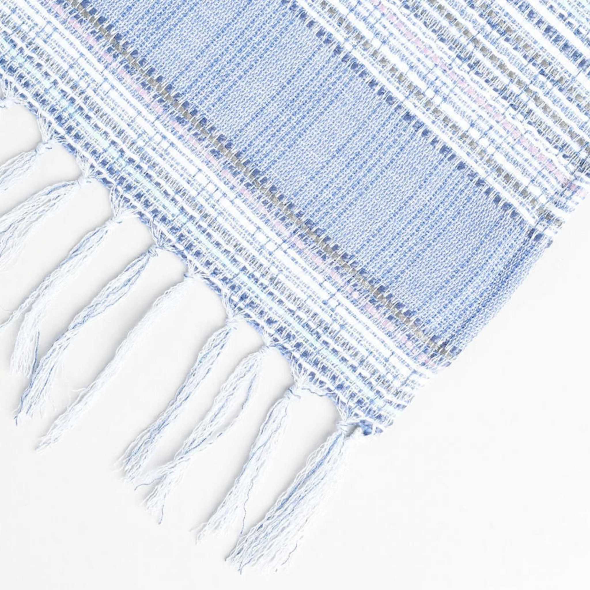 light periwinkle summer blanket displayed to show the blue tassels