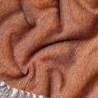 burnt colored orange throw blanket with tassels and woven textured look