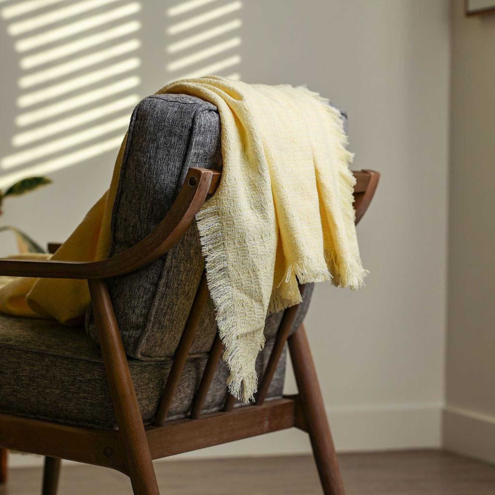 light yellow coloured throw blanked styled over a couch for a minimalist style decor